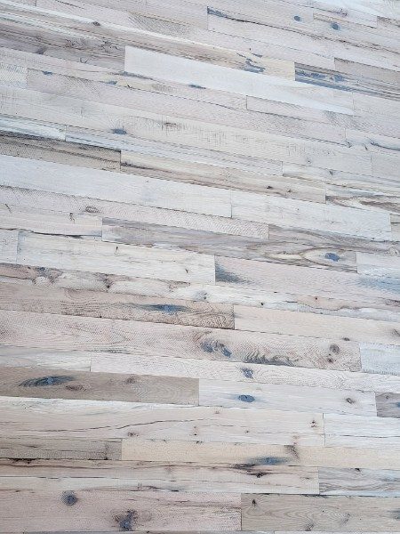 Weathered reclaimed planks in grey and cream tones laid in a random pattern