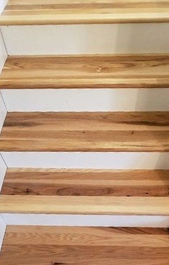 The same staircase finished with clean hickory treads against white risers